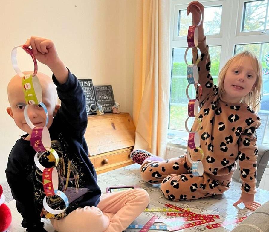 Two girls making paper chains